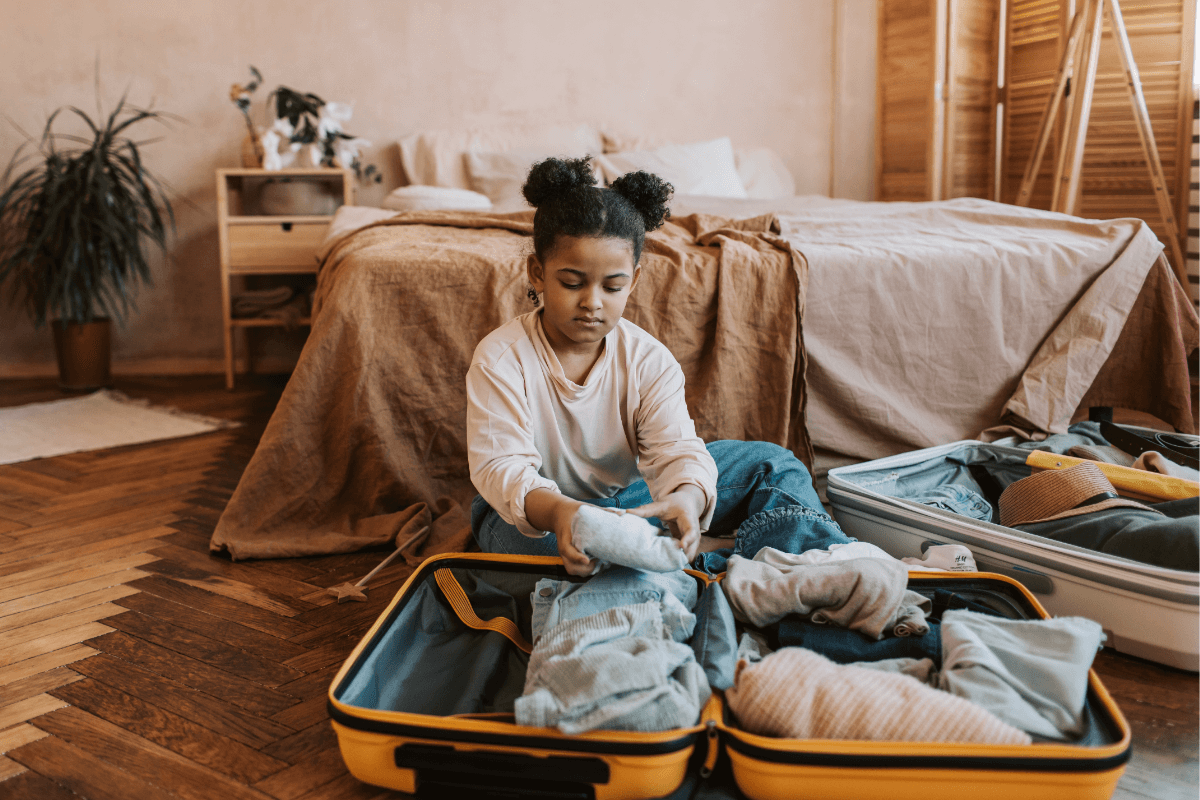 Trauriges Mädchen packt Koffer aus als Bild für den Blog nach dem Urlaub