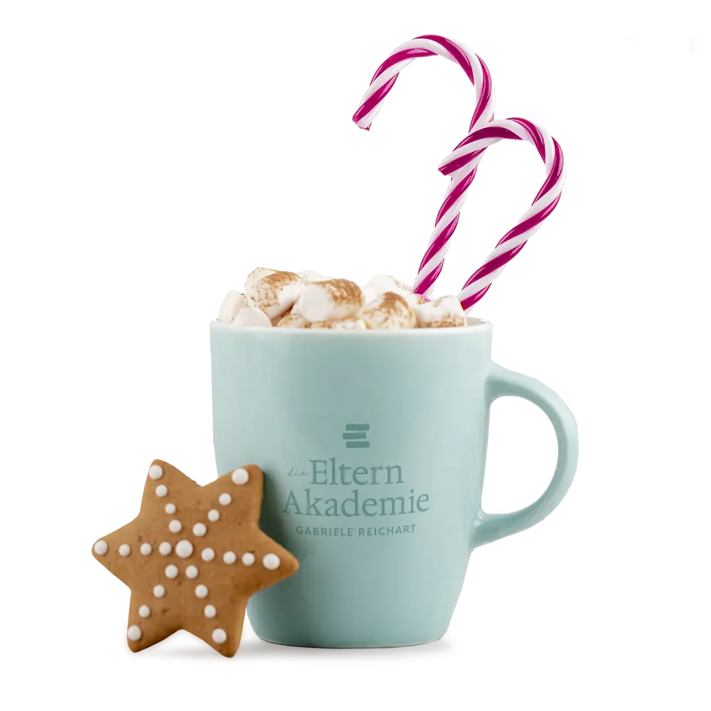 Türkise Tasse mit dem Logo der Eltern Akademie, gefüllt mit heißem Kakao plus kleinen Marshmallows und zwei Zuckerstangen und davor ein Weihnachtsplätzchen als Symbol für die Gemütlichkeit mit dem Adventskalender für Eltern und Kind.