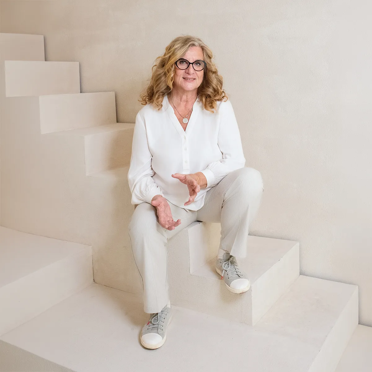 Gabriele Reichart, Dipl. Sozialpädagogin, Erzieherin und zweifache Mutter, sitzt für die Über mich Seite auf einer Treppe und zeigt Eltern, wie der Familien­alltag ohne Schimpfen wieder entspannt und leicht wird.