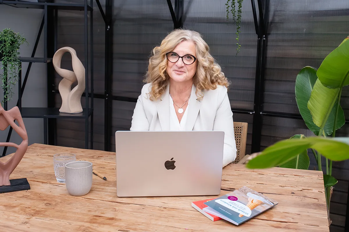 Gabriele Reichart, Interviewpartnerin, Speakerin und Expertin für liebevolle Erziehung, sitzt hinter ihrem Laptop.